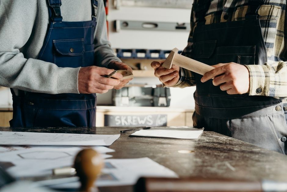 Two people reviewing sketches and materials together at a worktable.
